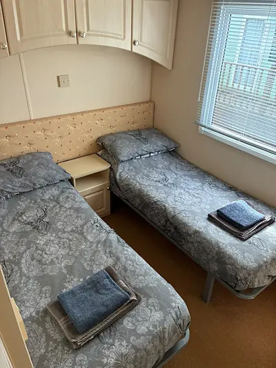 The twin bedroom in The West Lakes Caravan with a single bed made up.